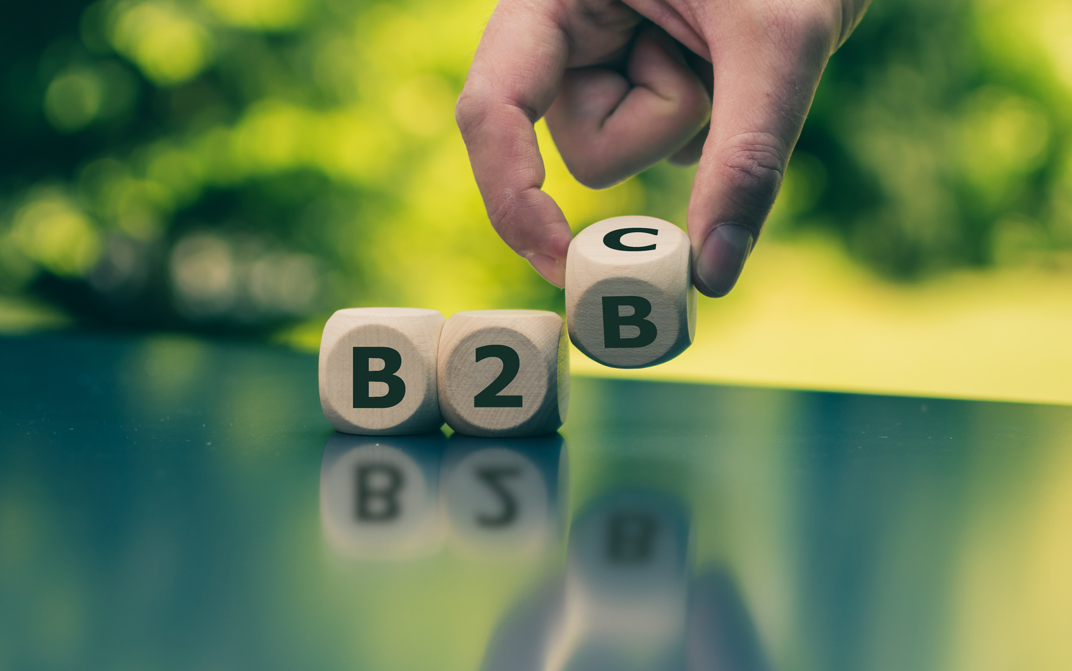 Business to Business or Busness to Consumer? Hand turns a dice and changes the expression "B2B" to "B2C" (or vice versa)